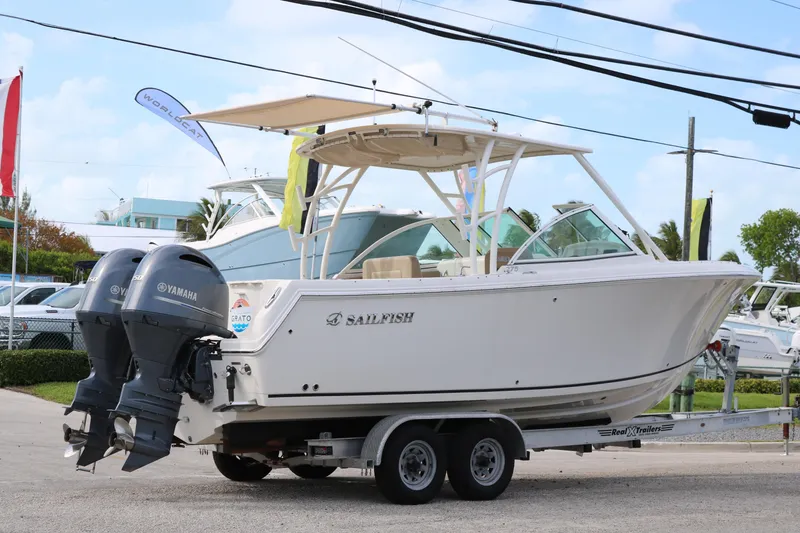 Slide: The Image of 2020 Sailfish 275 DC boat on trailer with Yamaha engines, parked outdoors. - 4