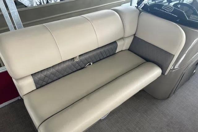 Slide: The Image of 2022 Sun Tracker Fishin' Barge 24 DLX interior with beige cushioned seating. - 10