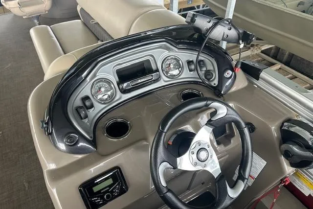 Slide: The Image of 2022 Sun Tracker Fishin' Barge 24 DLX dashboard with steering wheel and gauges. - 13