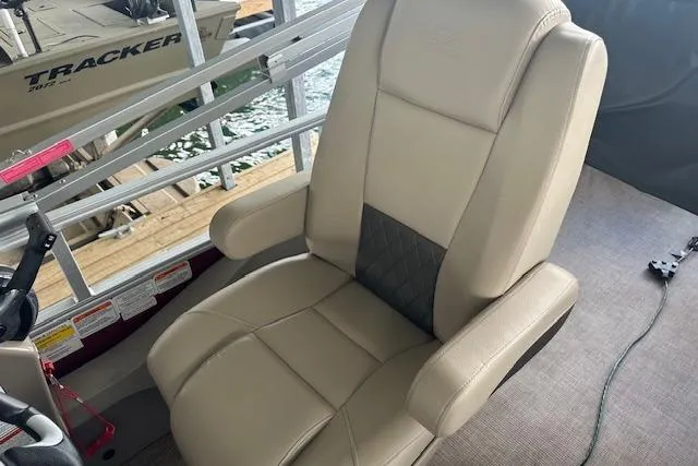 Slide: The Image of 2022 Sun Tracker Fishin' Barge 24 DLX captain's chair, beige with black accent, on deck. - 15
