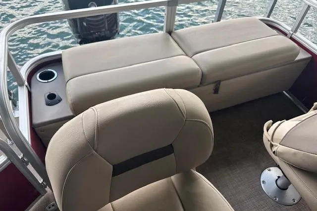 Slide: The Image of 2022 Sun Tracker Fishin' Barge 24 DLX interior with beige seating and cup holder. - 16