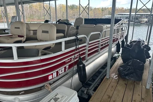 Slide: The Image of 2022 Sun Tracker Fishin' Barge 24 DLX pontoon boat docked in a marina. - 3