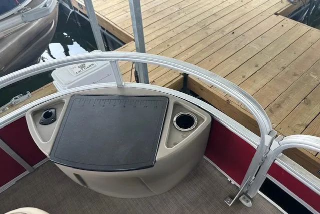 Slide: The Image of 2022 Sun Tracker Fishin' Barge 24 DLX at dock, featuring fishing station and cup holder. - 6