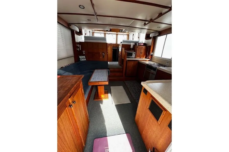 Slide: The Image of Interior of a 2006 Nordic Tug 37, featuring wood cabinetry and seating area. - 10