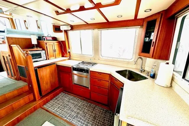Slide: The Image of 2006 Nordic Tug 37 interior kitchen with wood cabinetry and modern appliances. - 13