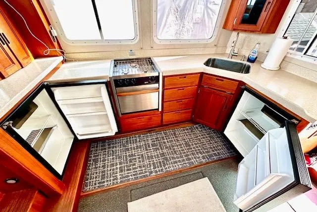 Slide: The Image of Interior of 2006 Nordic Tug 37 kitchen with open fridge, stove, and sink. - 14