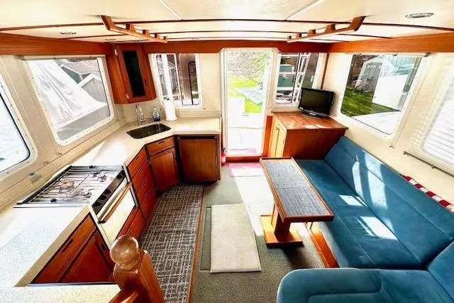 Slide: The Image of Interior of a 2006 Nordic Tug 37, featuring a cozy kitchen and seating area. - 15