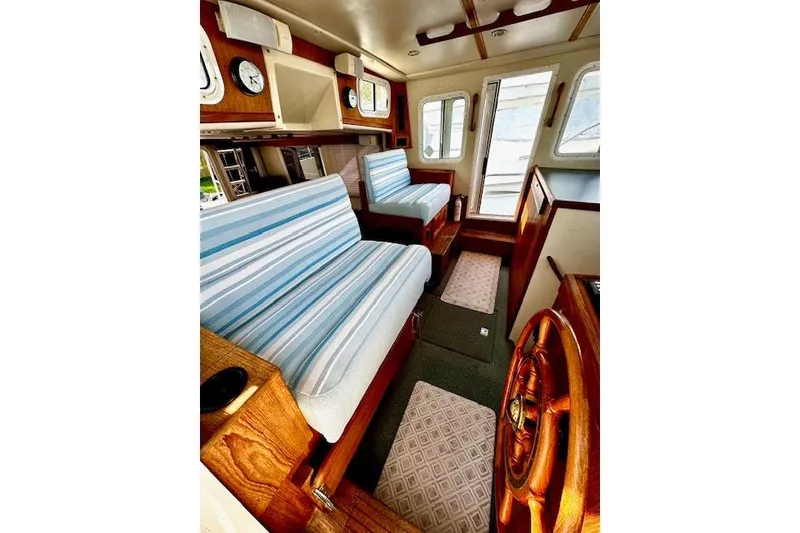 Slide: The Image of Interior of a 2006 Nordic Tug 37 with striped seating and wooden accents. - 17