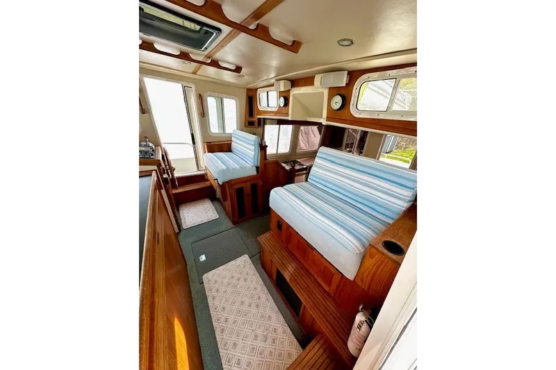 Slide: The Image of Interior of a 2006 Nordic Tug 37 with striped seating and wooden accents. - 19