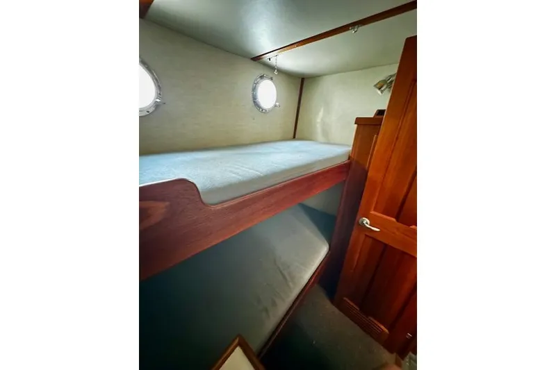 Slide: The Image of Cozy bunk beds in 2006 Nordic Tug 37 cabin with porthole windows. - 29