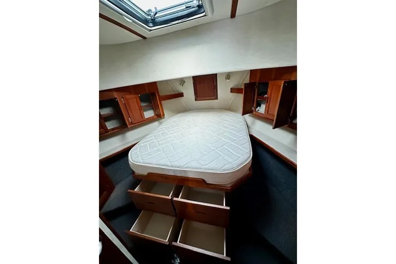 Slide: The Image of 2006 Nordic Tug 37 interior cabin with bed, storage drawers, and wooden cabinetry. - 31