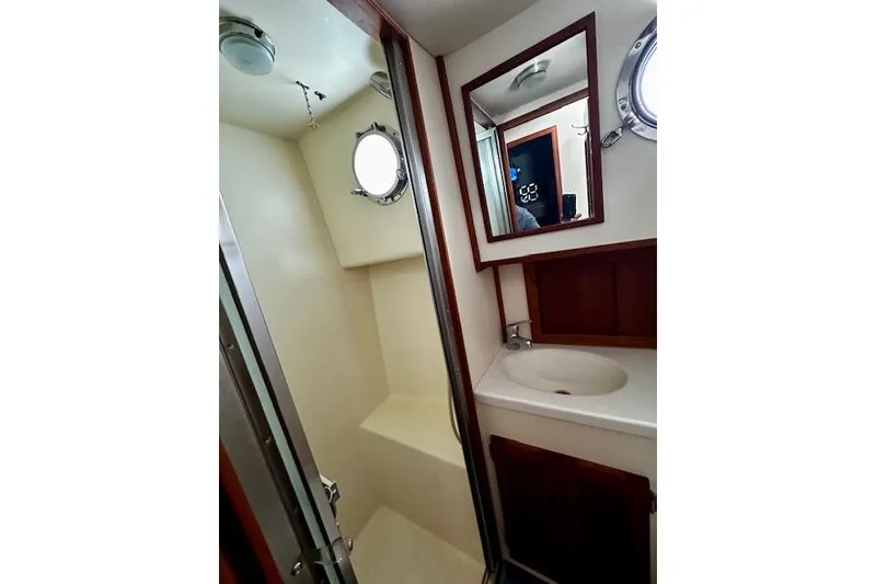 Slide: The Image of Bathroom interior of 2006 Nordic Tug 37 with sink, mirror, and porthole window. - 35