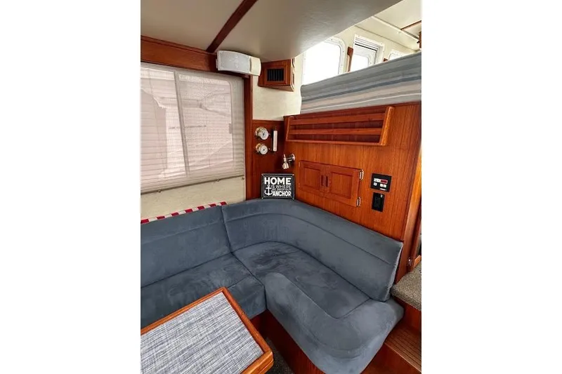 Slide: The Image of Cozy interior of 2006 Nordic Tug 37 with blue seating and wooden accents. - 36