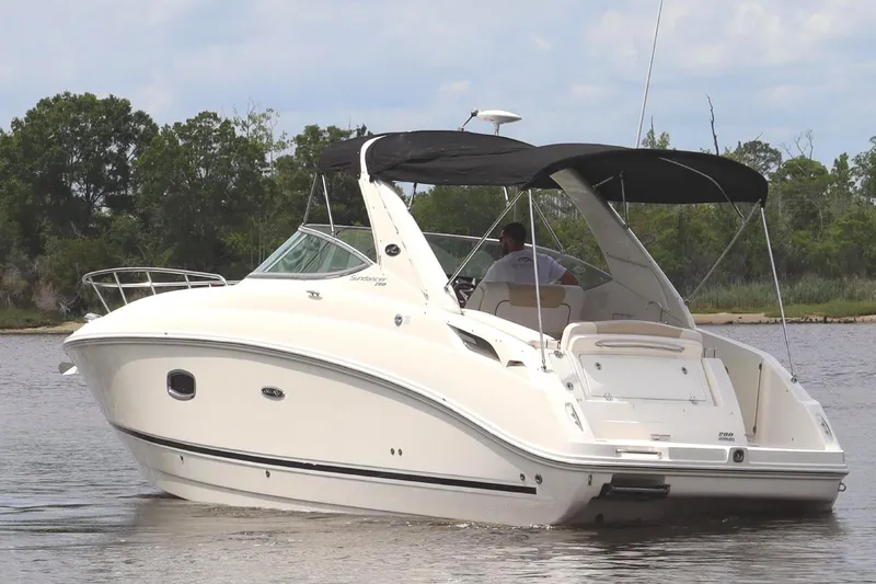 Slide: The Image of 2011 Sea Ray Sundancer 280 boat on trailer, parked outdoors near palm trees. - 11