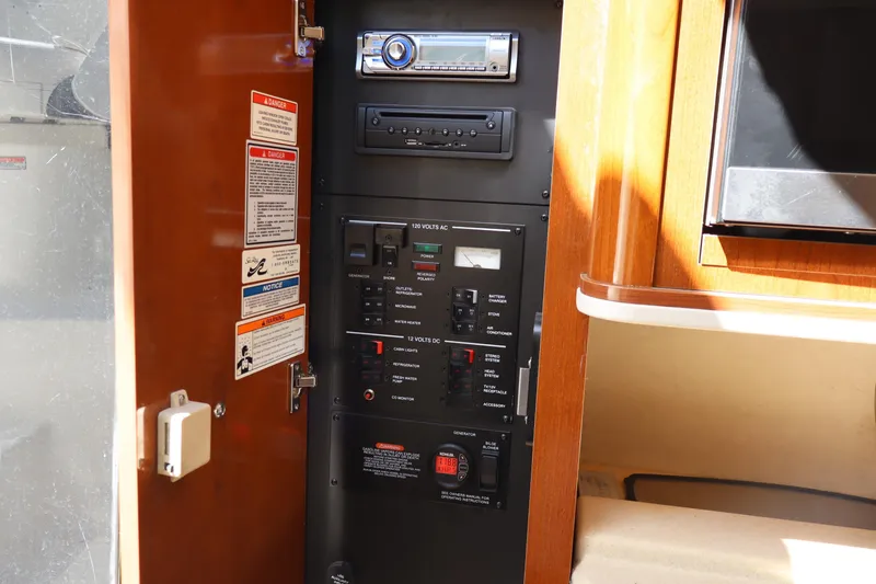 Slide: The Image of Control panel inside a 2011 Sea Ray Sundancer 280 boat, featuring electrical switches and stereo system. - 40