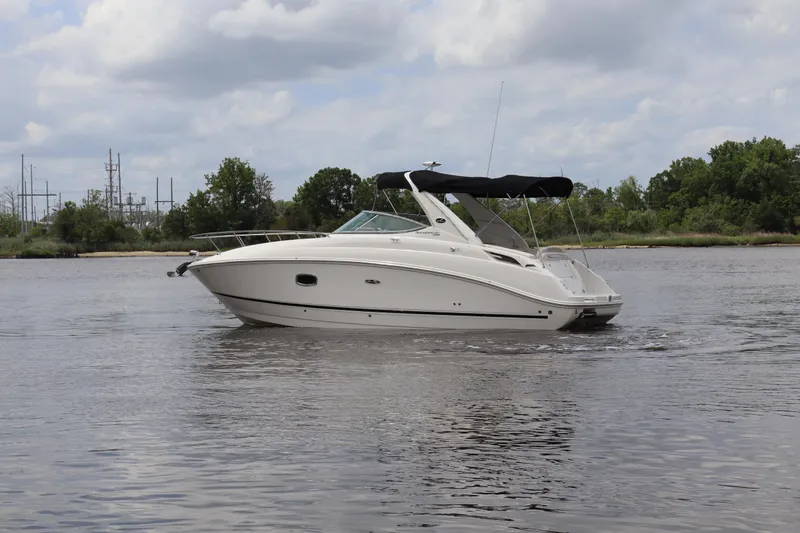 Slide: The Image of 2011 Sea Ray Sundancer 280 boat cruising on a calm river under a cloudy sky. - 50