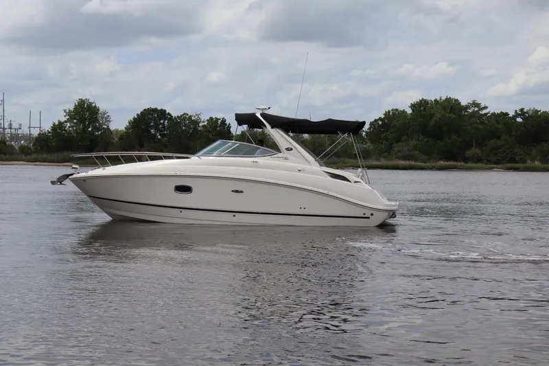 Slide: The Image of 2011 Sea Ray Sundancer 280 cruising on a calm river under a cloudy sky. - 52