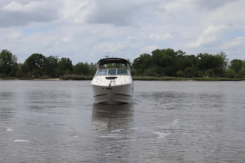 Slide: The Image of 2011 Sea Ray Sundancer 280 boat on calm water with lush green shoreline. - 62