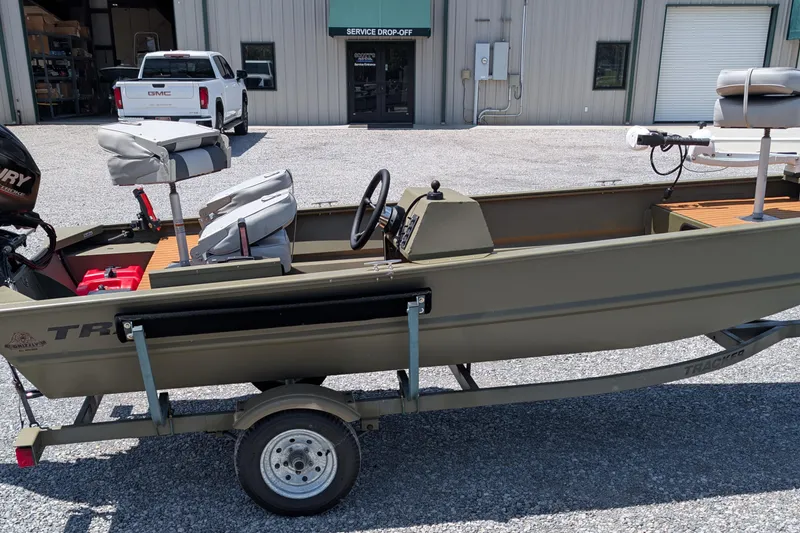 The Image of 2014 Bass Tracker boat on trailer, parked outside service drop-off area. - 0