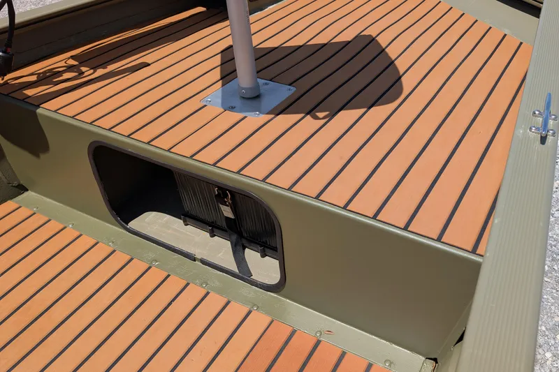 Slide: The Image of 2014 Bass Tracker boat deck with wood-like flooring and storage compartment. - 10