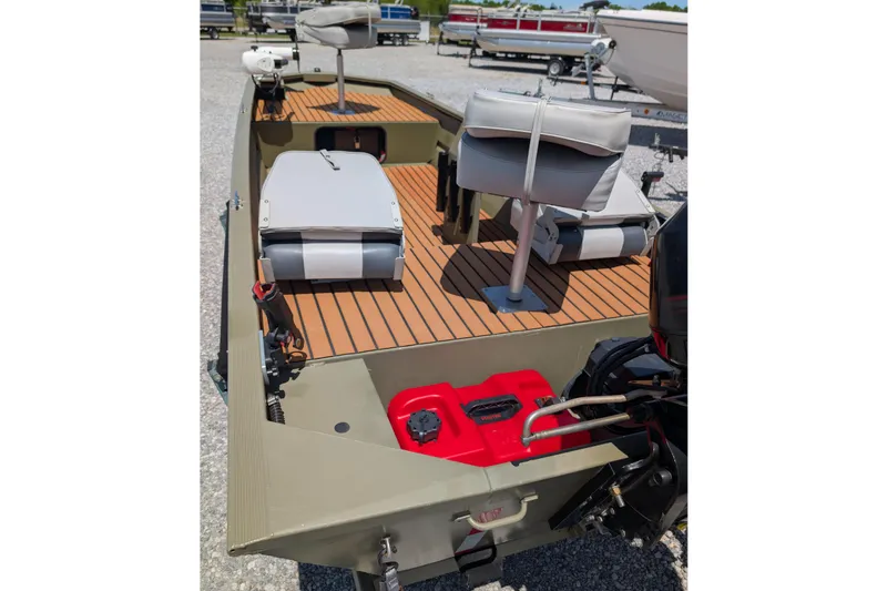 Slide: The Image of 2014 Bass Tracker boat interior with seating and motor, parked on gravel. - 4