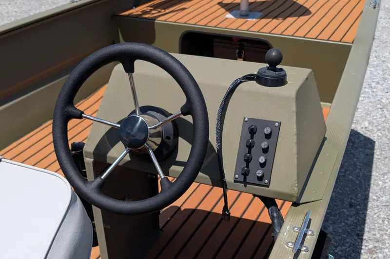 Slide: The Image of 2014 Bass Tracker boat steering wheel and control panel on wooden deck. - 6