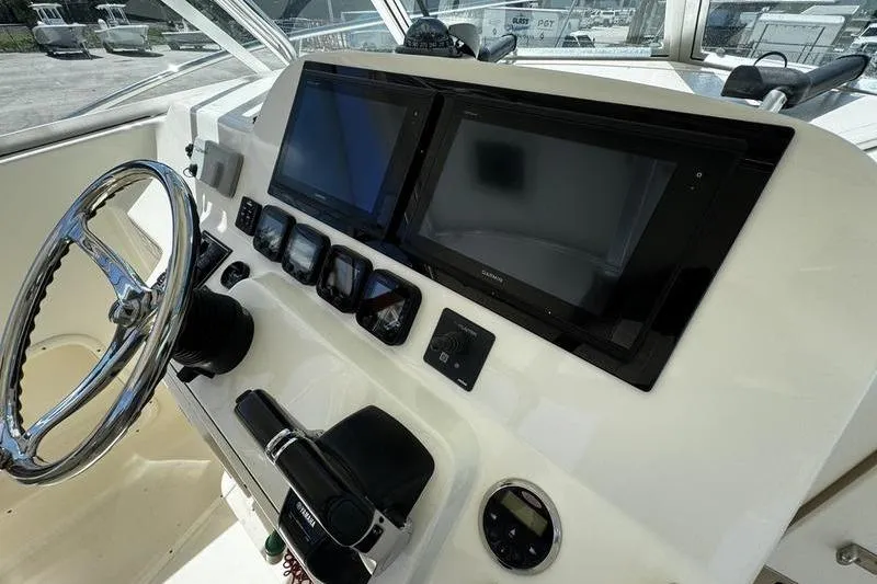 Slide: The Image of 2009 Pursuit 345 Drummond Runner LS helm with dual screens and steering wheel. - 14