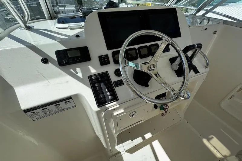 Slide: The Image of 2009 Pursuit 345 Drummond Runner LS helm with steering wheel and control panel. - 15