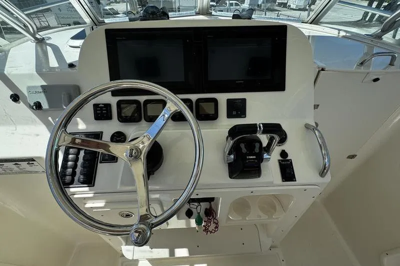 Slide: The Image of 2009 Pursuit 345 Drummond Runner LS boat helm with steering wheel and controls. - 16