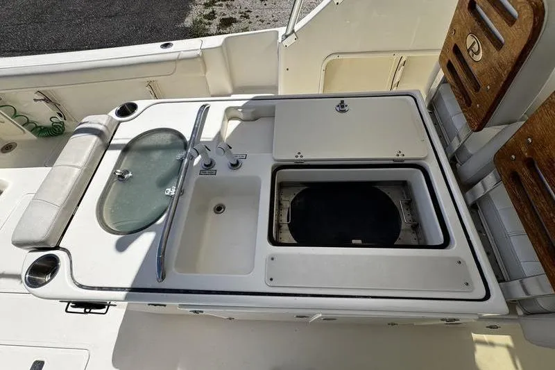 Slide: The Image of 2009 Pursuit 345 Drummond Runner LS boat deck with sink and storage compartments. - 18