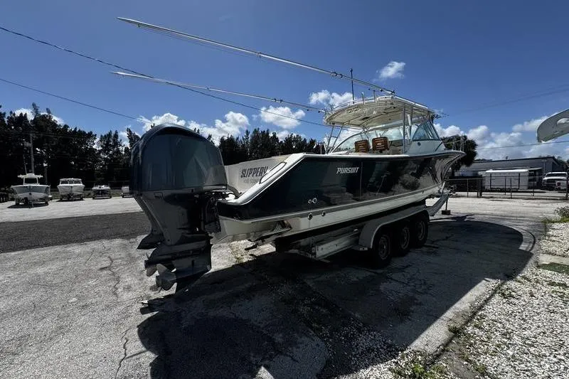 Slide: The Image of 2009 Pursuit 345 Drummond Runner LS boat on trailer under clear blue sky. - 2