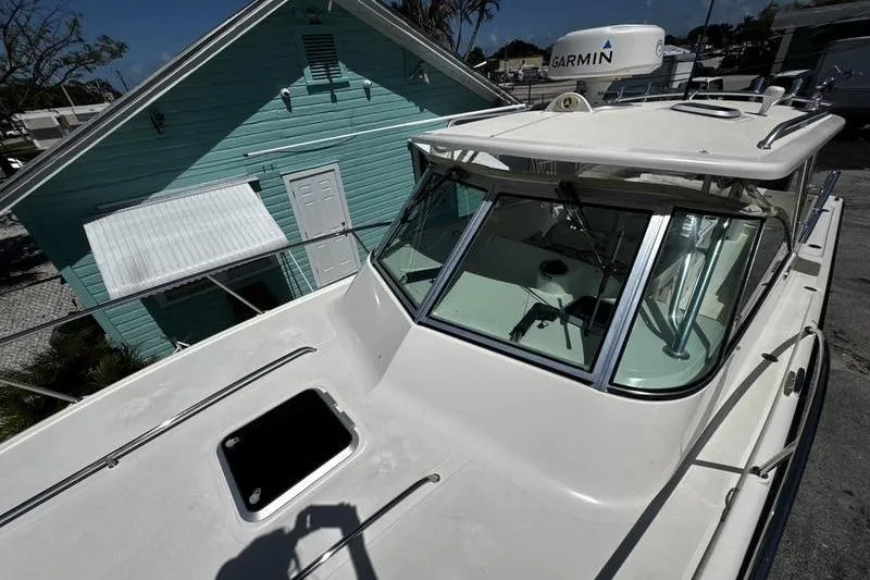 Slide: The Image of 2009 Pursuit 345 Drummond Runner LS boat docked near a turquoise building. - 23