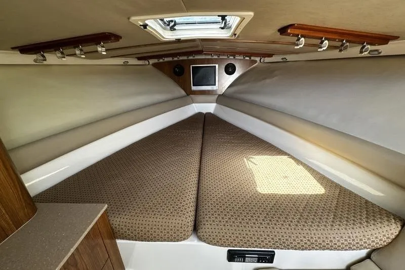 Slide: The Image of 2009 Pursuit 345 Drummond Runner LS cabin interior with cushioned seating and overhead hatch. - 39