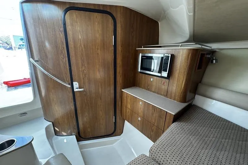 Slide: The Image of Interior of 2009 Pursuit 345 Drummond Runner LS with wood paneling and microwave. - 42