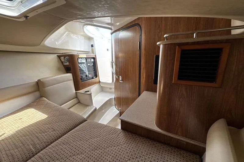 Slide: The Image of Interior of 2009 Pursuit 345 Drummond Runner LS boat, featuring cozy cabin and wood accents. - 43