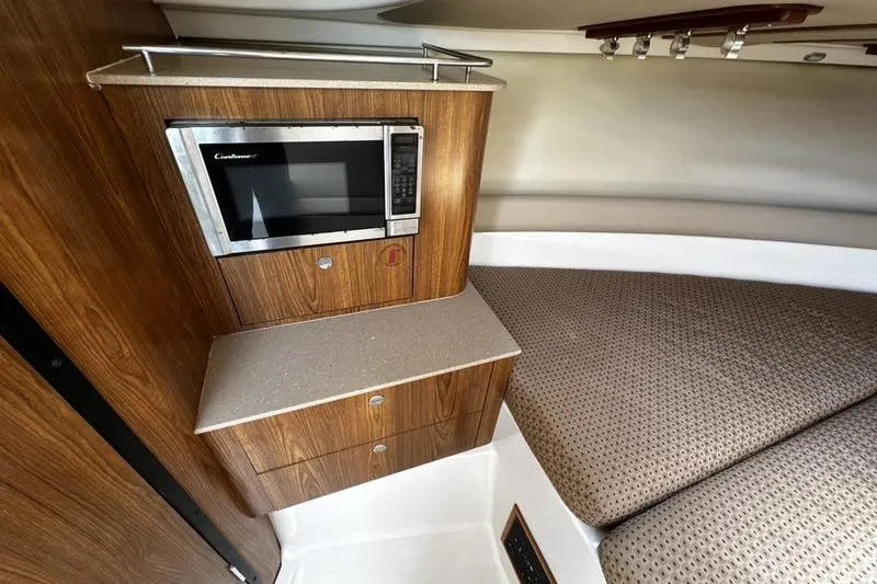 Slide: The Image of Interior of 2009 Pursuit 345 Drummond Runner LS with microwave and cushioned seating area. - 47