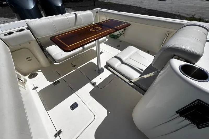 Slide: The Image of 2009 Pursuit 345 Drummond Runner LS boat interior with seating and wooden table. - 49