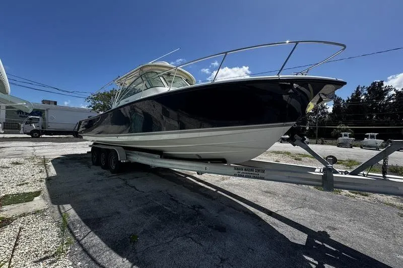 Slide: The Image of 2009 Pursuit 345 Drummond Runner LS boat on trailer under clear blue sky. - 5