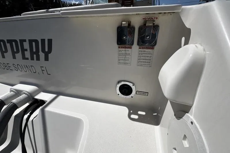 Slide: The Image of 2009 Pursuit 345 Drummond Runner LS boat deck with electrical outlets and warning labels. - 52
