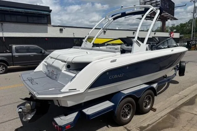 Slide: The Image of 2024 Cobalt CS22 boat on trailer, parked on street, showcasing sleek design and dual-axle trailer. - 3