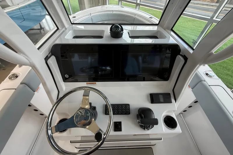 Slide: The Image of 2026 Sportsman Open 232 Center Console helm with steering wheel and navigation display. - 10