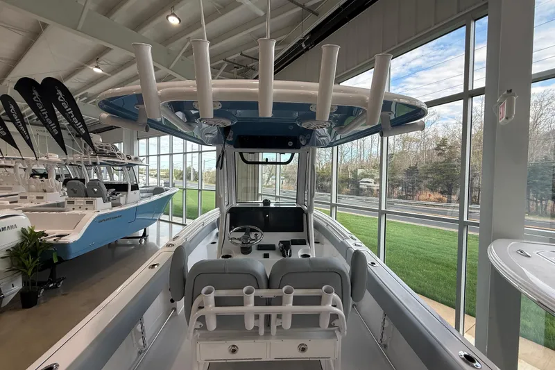 Slide: The Image of 2026 Sportsman Open 232 Center Console boat displayed in a showroom with large windows. - 12