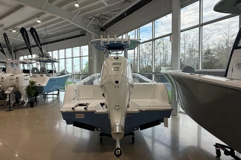 Slide: The Image of 2026 Sportsman Open 232 Center Console boat displayed in a showroom with large windows. - 2