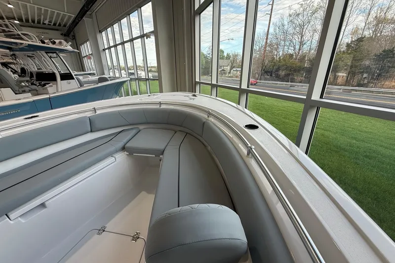 Slide: The Image of 2026 Sportsman Open 232 Center Console boat interior with cushioned seating in showroom. - 4