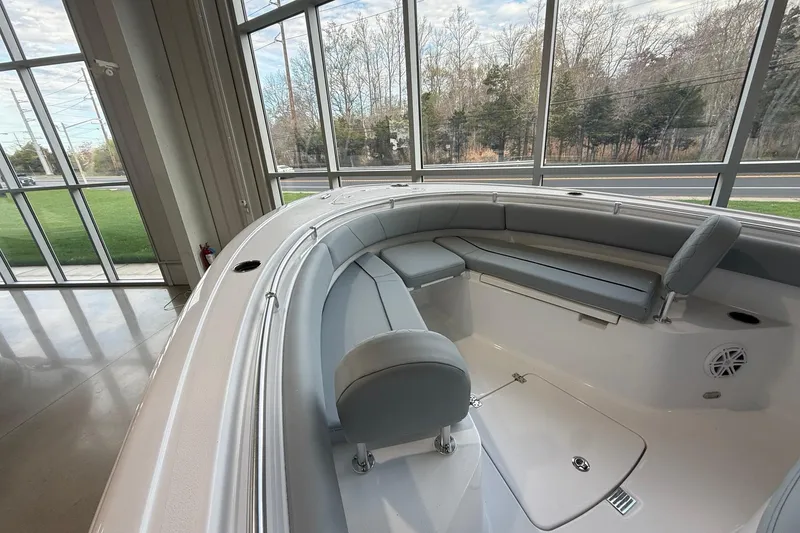 Slide: The Image of 2026 Sportsman Open 232 Center Console boat interior with cushioned seating in showroom. - 5