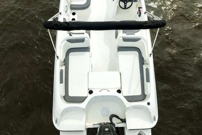 Slide: The Image of 2026 Bayliner Element E18 boat interior with seating, steering wheel, and motor on water. - 6
