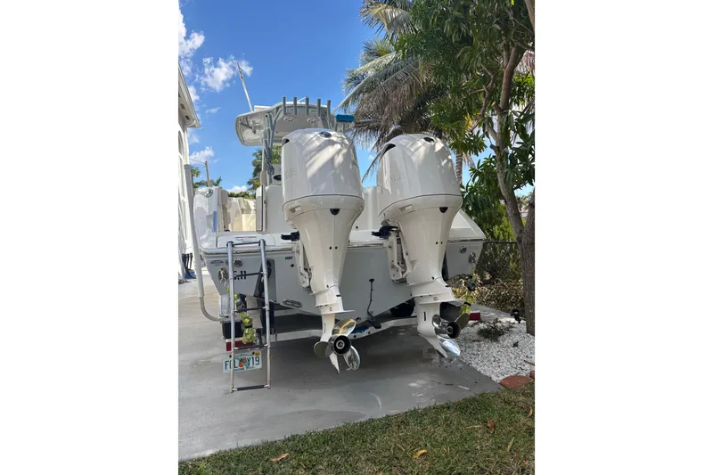 Slide: The Image of 2021 Cobia 320 Center Console boat with dual outboard motors, parked outdoors. - 9