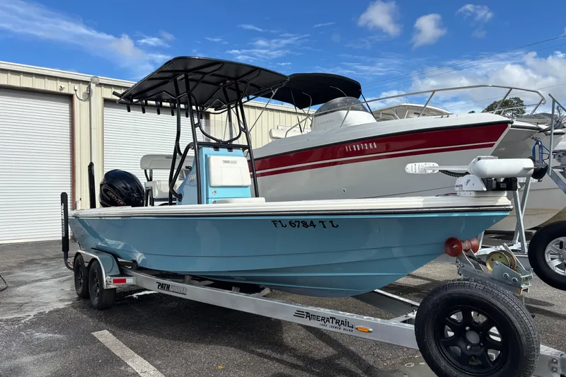 The Image of 2023 Pathfinder 2300 HPS boat on trailer, parked outdoors under blue sky. - 1
