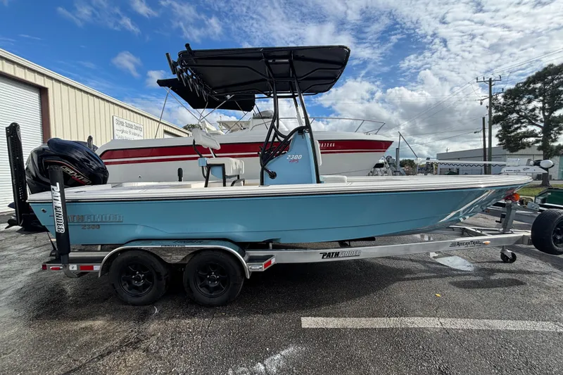 Slide: The Image of 2023 Pathfinder 2300 HPS boat on trailer, blue hull, parked outdoors. - 3