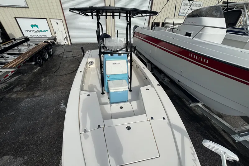 Slide: The Image of 2023 Pathfinder 2300 HPS boat at service center, parked beside another vessel. - 4